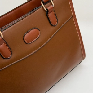 Retro dark brown leather tote bag with elegant gold metal rings and matte finish
