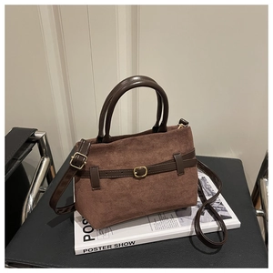 Gros plan d'un sac vintage en daim marron avec lanières en cuir et boucle dorée