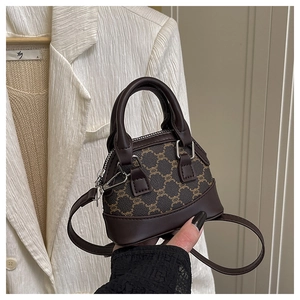 Close-up of mini shell bag showing vintage monogram pattern and brown leather handles