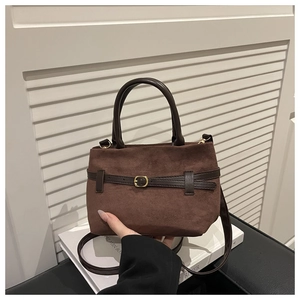 Gros plan du sac seau en daim mat avec lanière en cuir et boucle dorée élégante