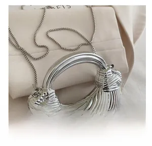 Dettaglio borsa a conchiglia argento con texture a spirale futuristica e tracolla catena
