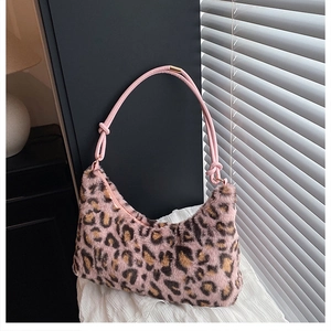 Close-up of pink leopard print faux fur hobo bag with knotted leather strap and metal buckle