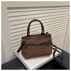 Vue détaillée du sac cabas en daim marron avec lanières en cuir et boucle dorée
