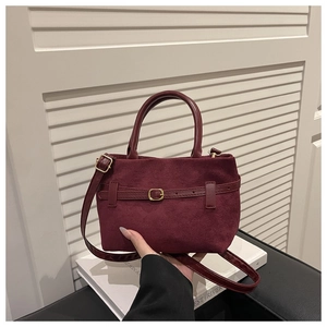 Détail du sac à main rétro bordeaux en suède avec boucle dorée et décor de ceinture
