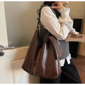 Detail view of dark brown PU leather hobo tote bag with matching inner zipper pouch