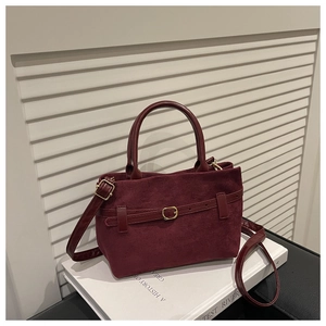 Détail du sac seau bordeaux en cuir givré avec boucle dorée et bandoulière chic