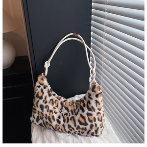 Detail of leopard print faux fur crescent bag with decorative woven rope shoulder strap