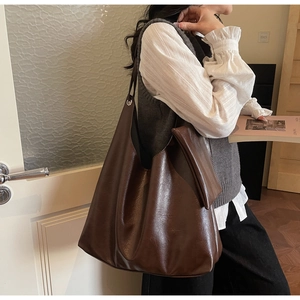 Detail of a dark brown PU leather hobo bag with inner pouch and metal buckle hardware