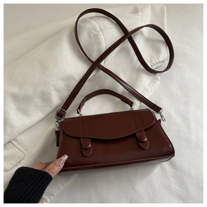 Front view of vintage dark brown faux leather handbag with dual buckle flip cover detail