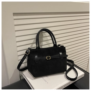 Gros plan du sac à main en daim noir avec lanières en cuir et boucle dorée