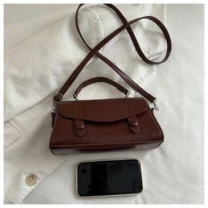 Top-down view of a small dark brown retro PU leather underarm bag with silver hardware