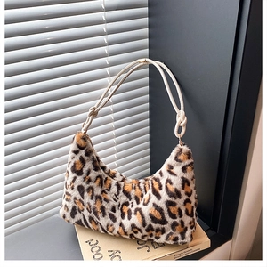 Detail of leopard print faux fur tote bag with a cream knotted shoulder strap on a windowsill
