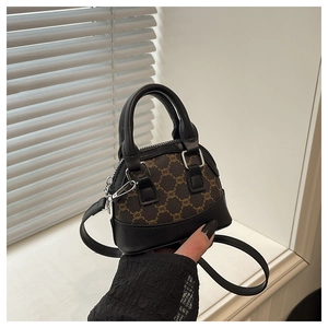Detail of mini shell bag showing vintage monogram pattern and black leather handles