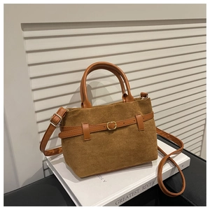 Détail du sac cabas en daim marron avec bandoulière réglable et boucle décorative