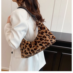 Close-up of a leopard print plush shoulder bag styled with a minimalist white blazer