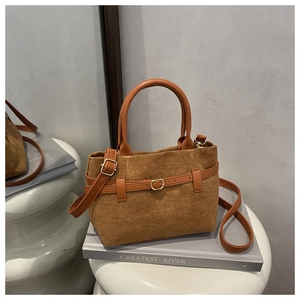 Détail du sac vintage en daim marron avec garniture en cuir et boucle dorée
