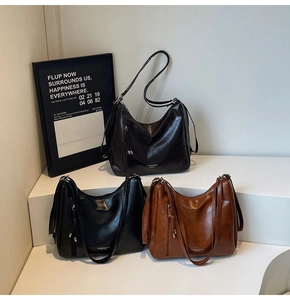 Close-up of three vintage oversized tote bags in dark brown, black, and caramel faux leather
