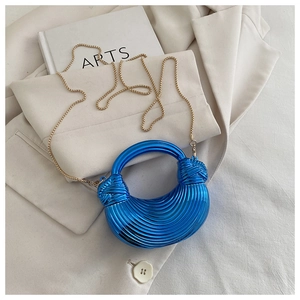 Détail du sac croissant bleu électrique à texture plissée et bandoulière chaîne dorée