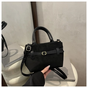 Détail du sac cabas en daim noir avec lanières en cuir lisse et boucle en métal doré