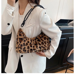 Chic leopard print plush crescent bag shown on a model with a black shoulder strap
