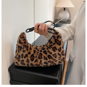 Detail of leopard print plush tote bag featuring soft fur texture and black knotted strap