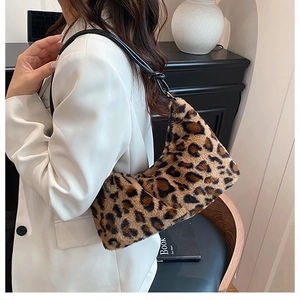 Dettaglio borsa a spalla in ecopelliccia leopardata con tracolla in pelle nera su modella