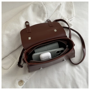 Interior view of dark brown leather underarm bag showing spacious storage compartments