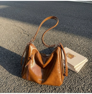 Close-up of brown vintage hobo bag featuring side zipper pocket and silver hardware