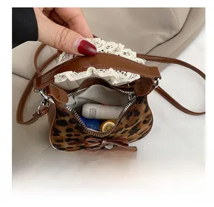 Detail shot of leopard print mini bag showing lipstick storage and lace trim edge