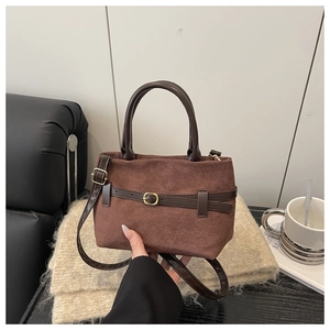 Détail du sac cabas vintage en daim marron avec lanières en cuir et boucles dorées
