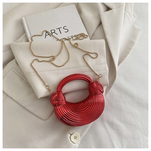 Vue détaillée du sac croissant rouge métallisé avec plis texturés et chaîne dorée