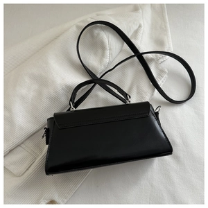 Detail view of the black faux leather crossbody bag with silver buckle and handle