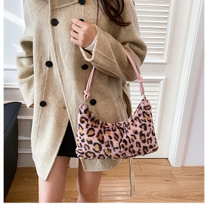 Detail of leopard print faux fur shoulder bag with pink knotted rope handle and gold hardware
