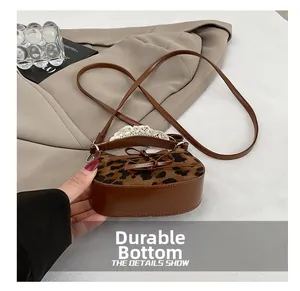 Dettaglio della base resistente della borsa leopardata con finiture in pelle