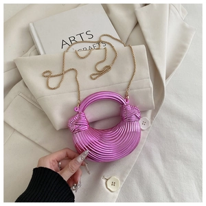 Détail du sac croissant violet brillant avec texture spirale et chaîne dorée fine