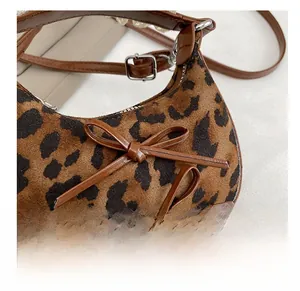 Dettaglio della borsa a mezzaluna leopardata in velluto con fiocchi in pelle marrone