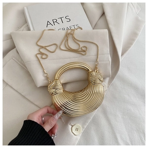 Détail du sac demi-lune doré avec effet miroir, texture tissée et poignée ronde