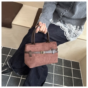Detail of vintage brown suede tote bag with decorative leather belt and gold buckle