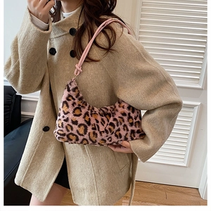 Borsa tote in ecopelliccia leopardata rosa con spalline sottili indossata su un cappotto