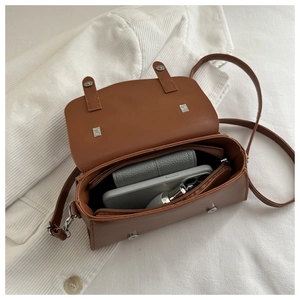 Internal compartments of a vintage brown crossbody bag showing storage for phone and wallet