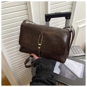 Détail du sac bandoulière vintage marron avec fermoir métallique et cuir texturé