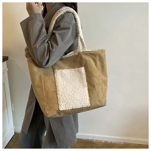 Side view of khaki tote bag with plush white fleece details on shoulder strap and pocket