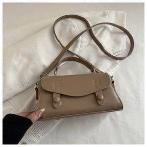 Close-up of khaki brown leather mini tote bag with dual decorative straps on knit fabric