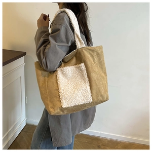 Detail of khaki corduroy tote bag with white faux fur strap worn by a model