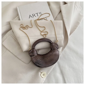 Détail du sac croissant bronze métallisé avec texture plissée et chaîne dorée