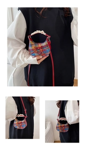 Detailed view of mini plaid crossbody bag with red bows and white lace handle details