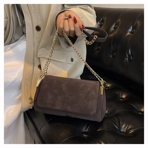 Detail of dark brown matte tote bag with cross-stitch and golden chain strap
