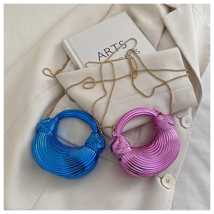 Mini sacs croissants métalliques bleu et rose avec bandoulière chaîne sur fond élégant