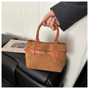 Détail d'un sac cabas en daim marron avec boucle de ceinture et poignée ronde