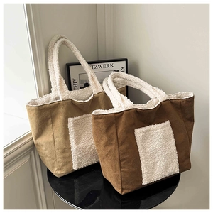 Detail of faux suede tote bags with white faux fur trim and large front pocket